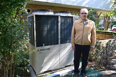 Brian Peck with heat pump outside