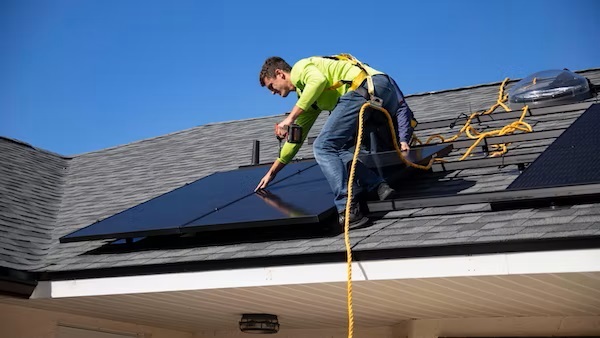 Man installing solar panels on a roof